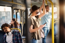 Riders sitting and standing on a bus